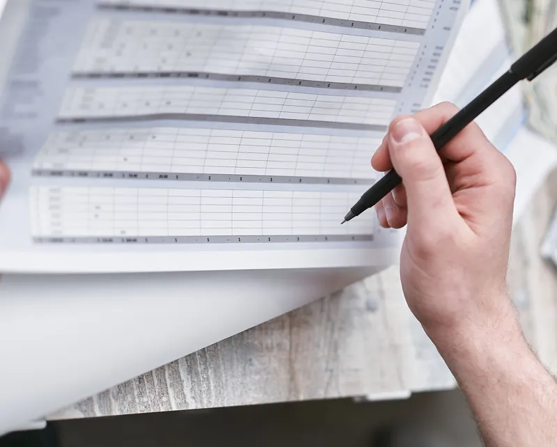 Analyst checking figures on a document with a pen
