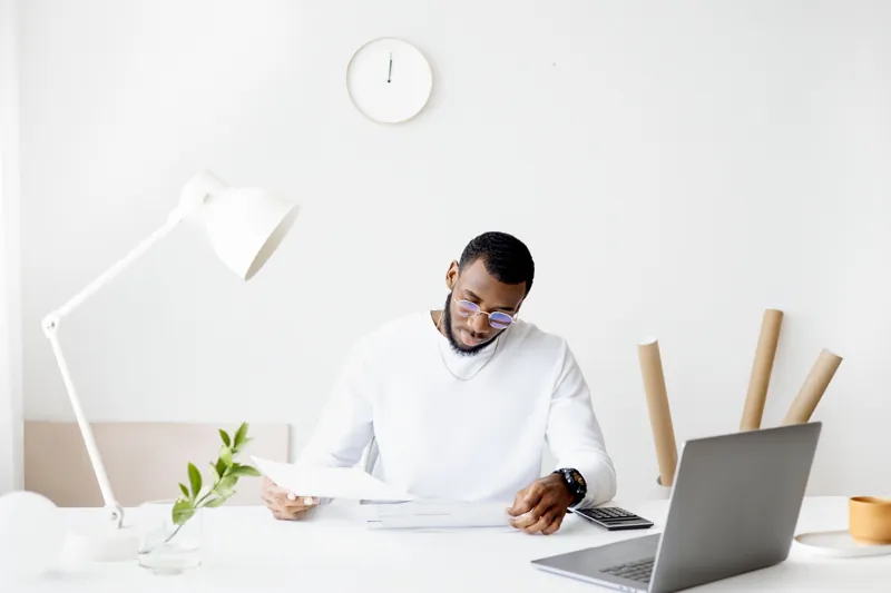 Person reviewing documents at a bright, minimal desk